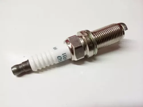 Toyota Yaris spark plug 90919-01233 with metal shell and ceramic insulator.